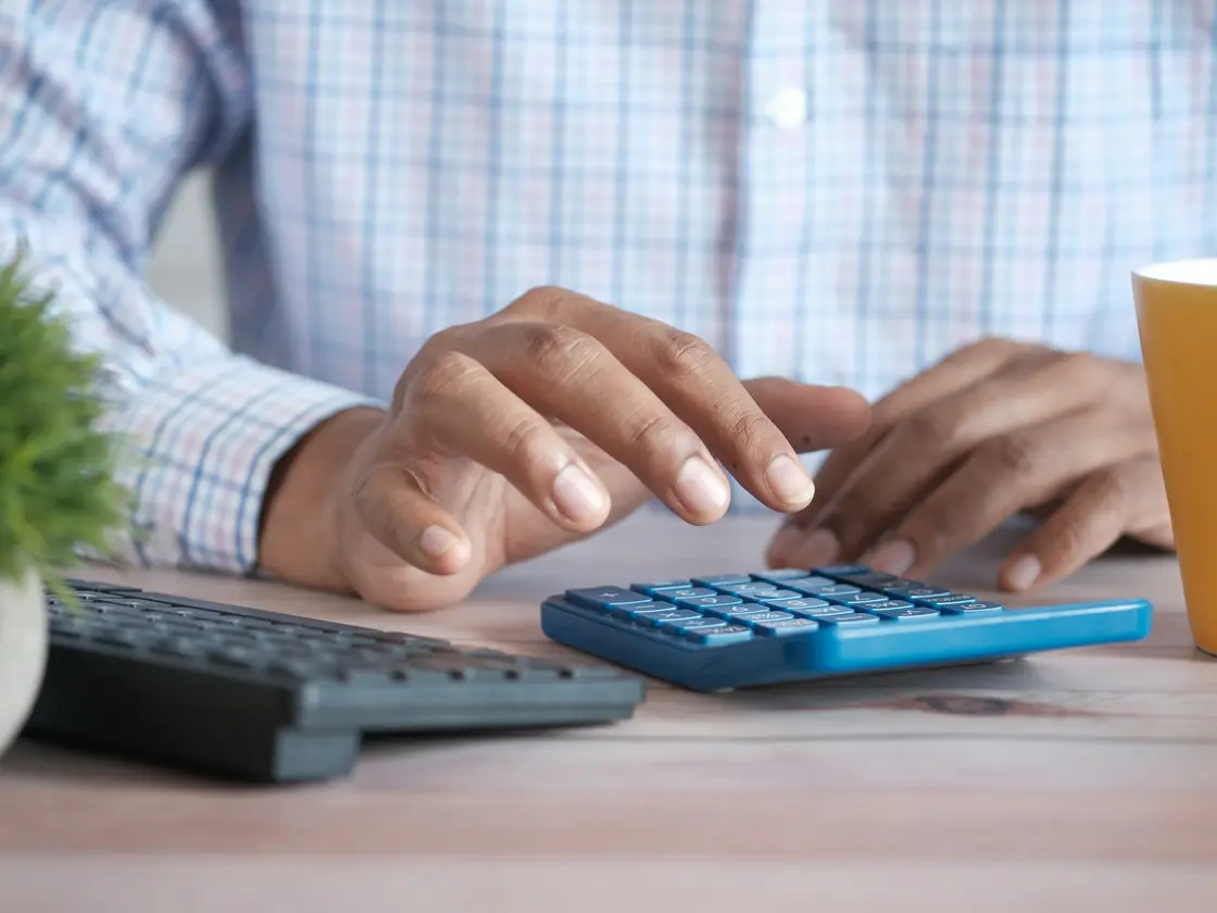 A person working through figures on a calculator at a desk