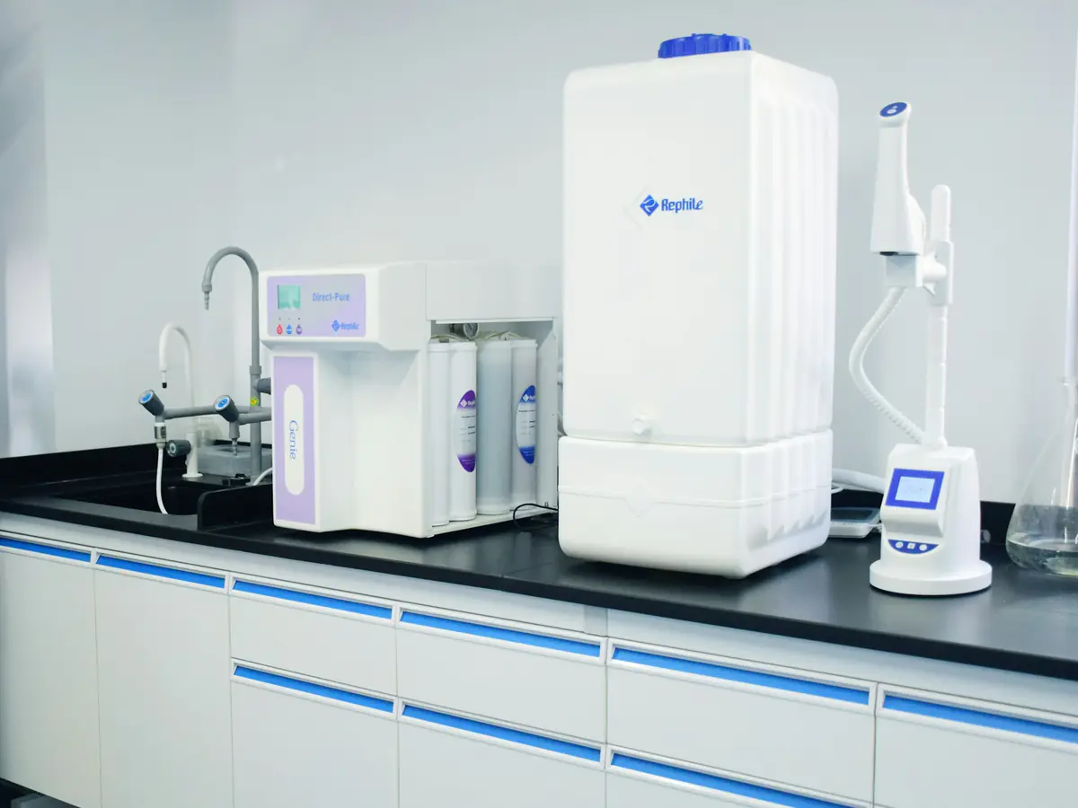 A countertop water purification unit beside a sink in a bright room