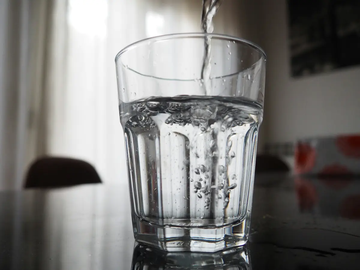 Water being poured into a clear drinking glass