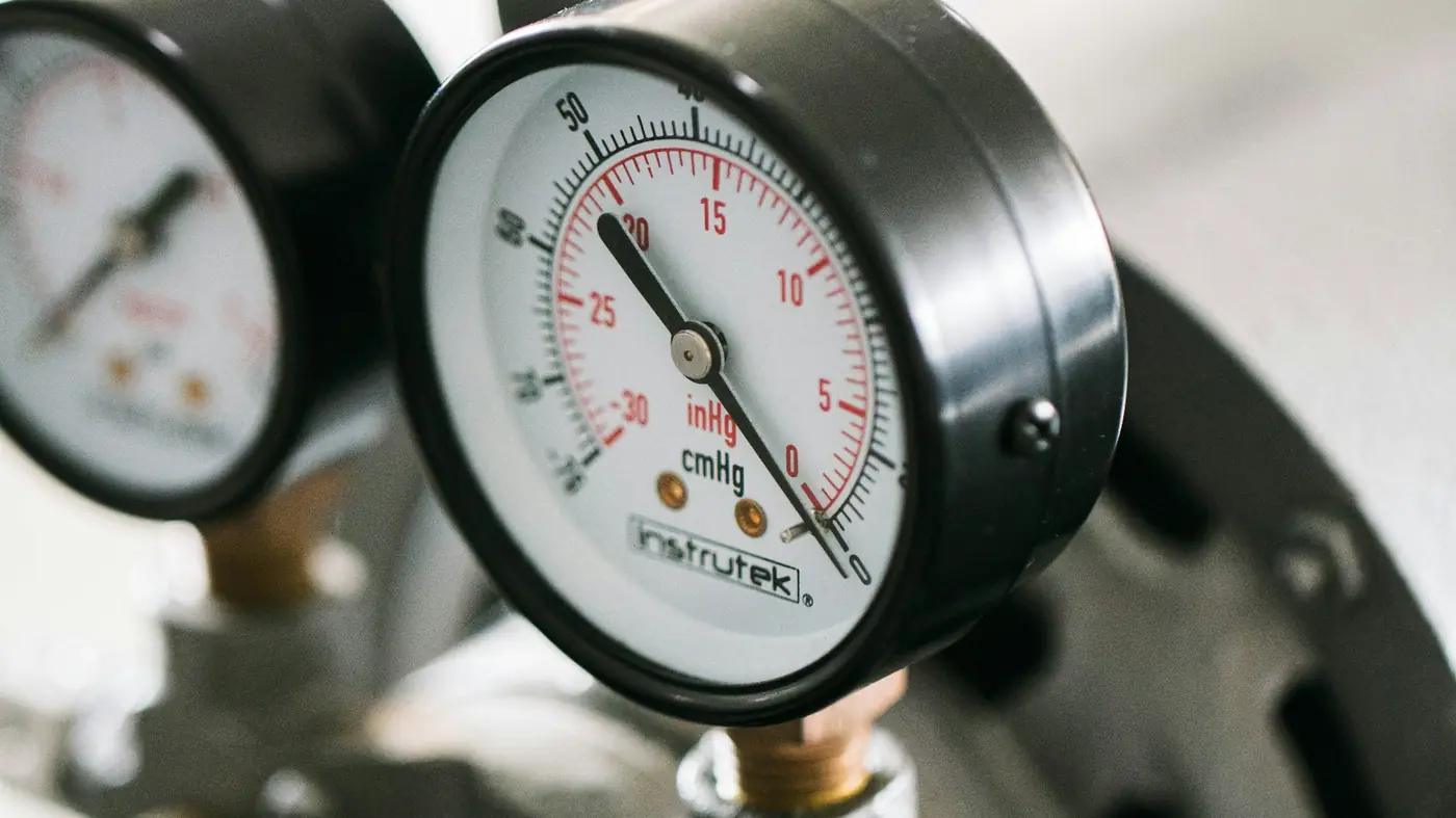 Two round pressure gauges on the valves of a water system