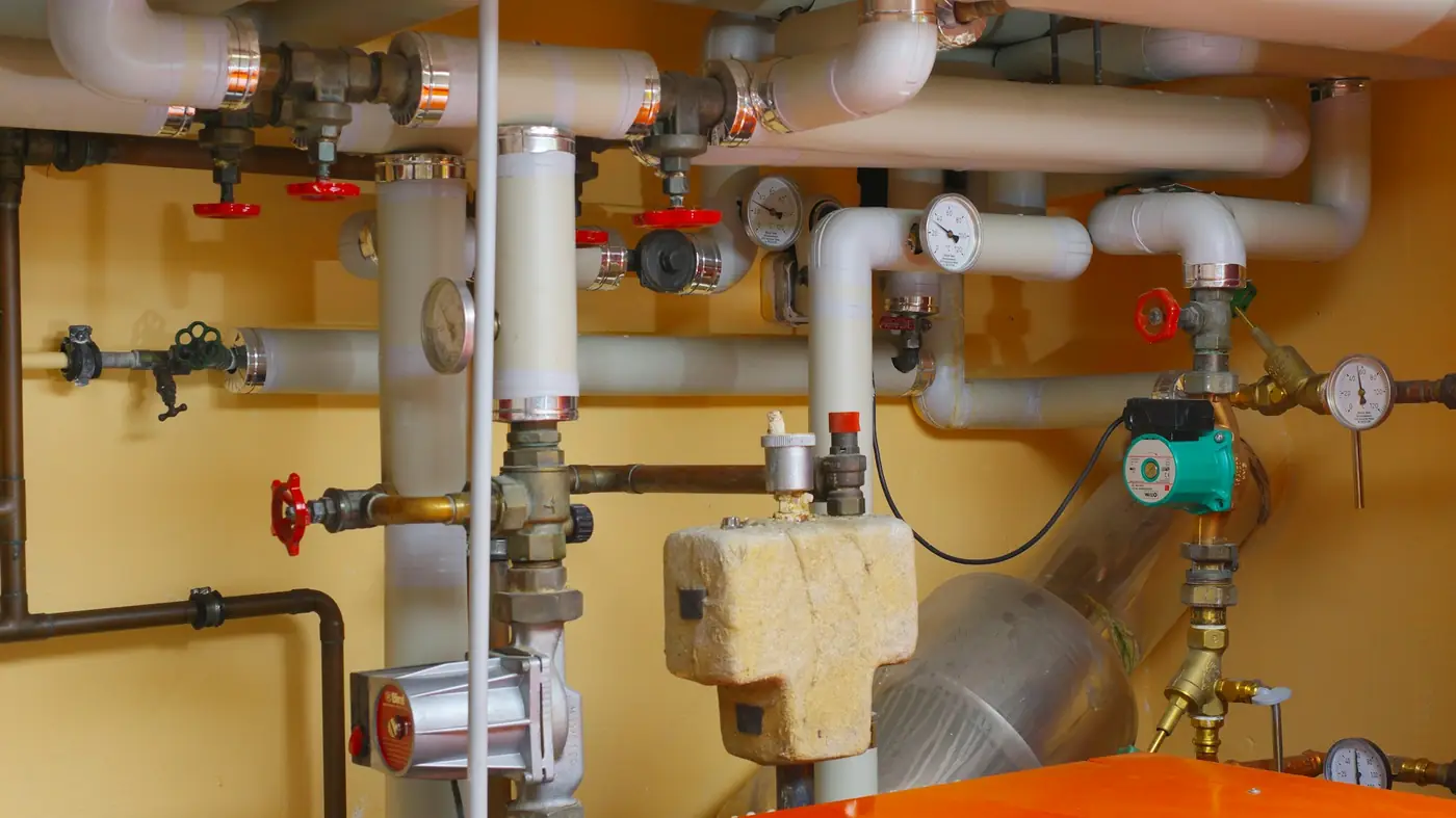 Water pipes, red valves and pressure gauges in a utility room